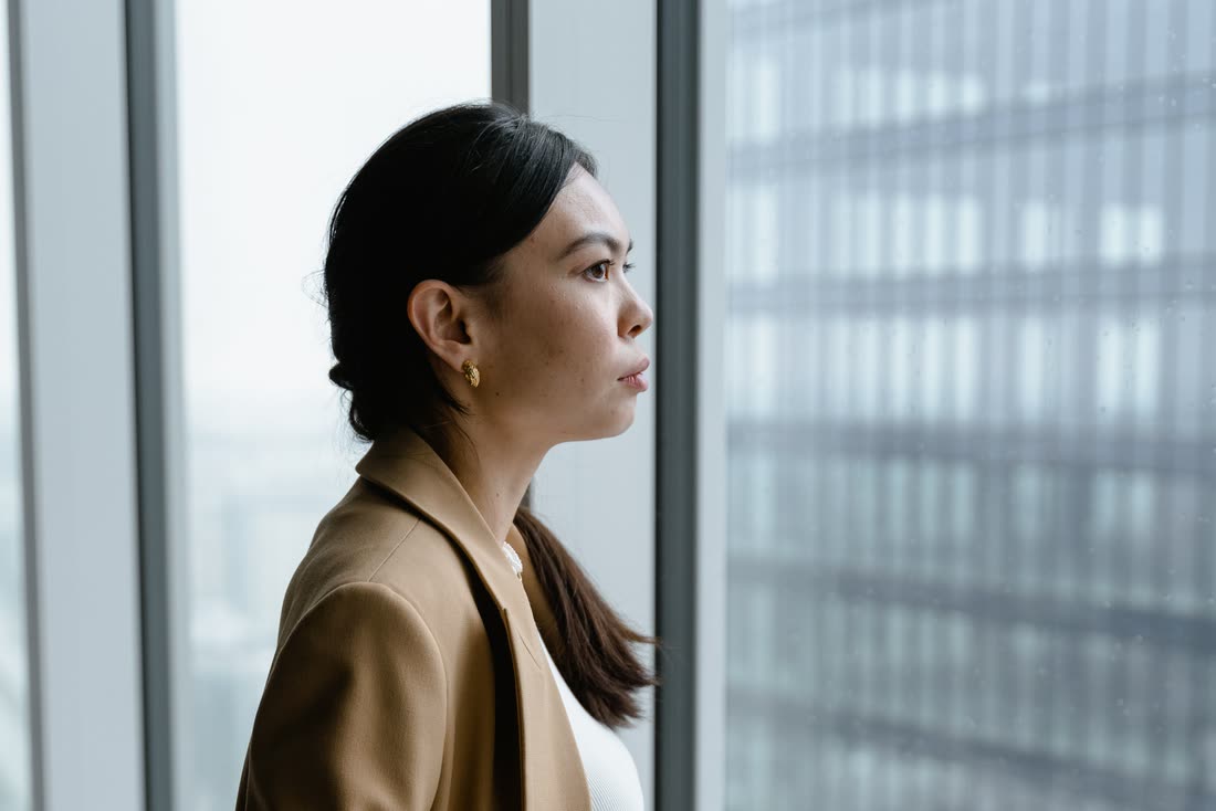 A practitioner thoughtfully looking out a window, weighing a decision